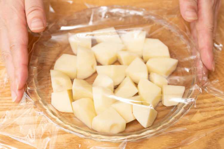 カットしたじゃがいもを入れた器にラップをかける